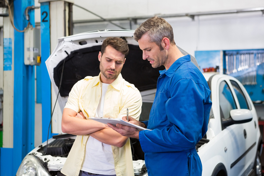 Customer listening to automotive technician at the repair garage